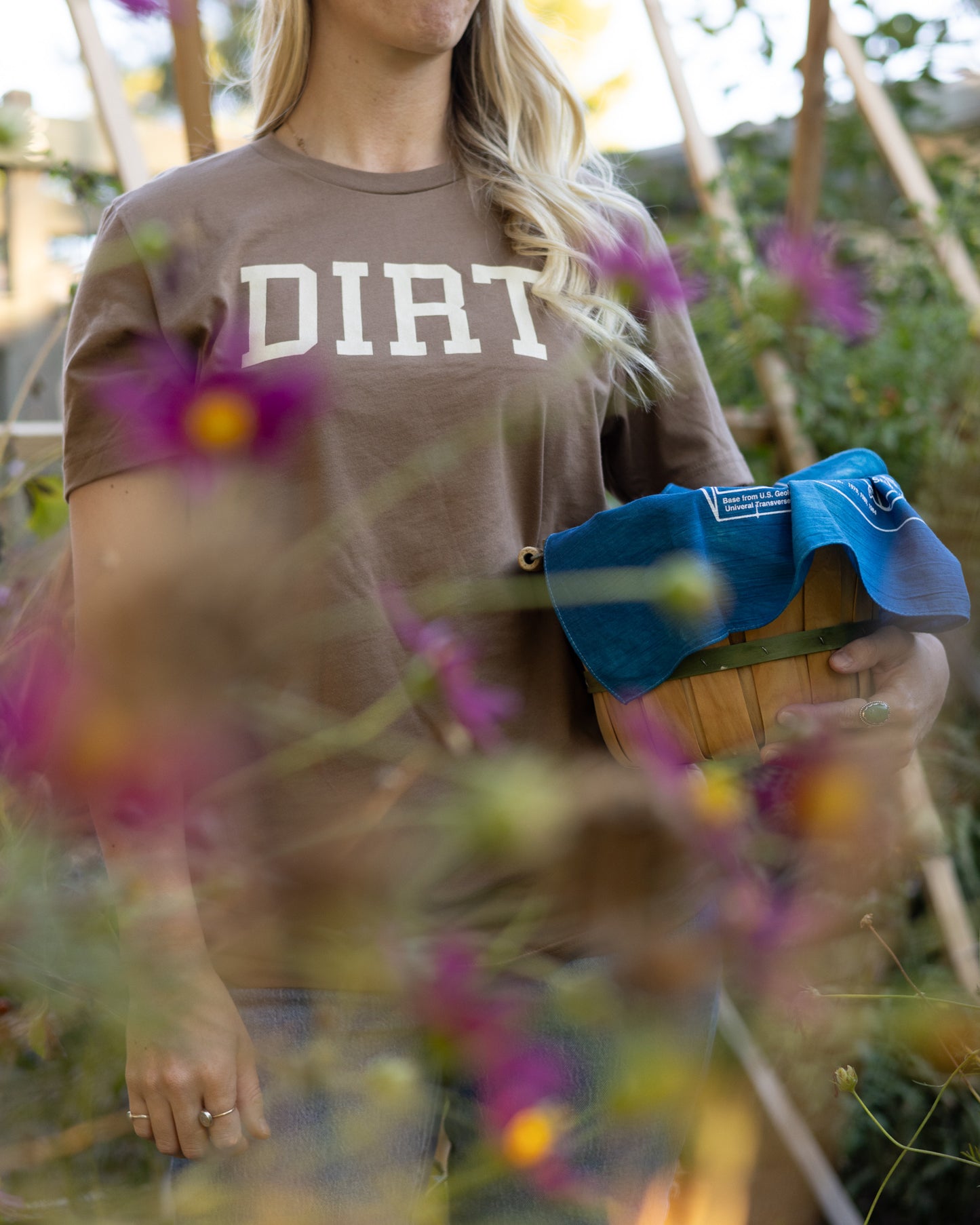 A person working in a garden while wearing The Dirt T in vintage brown, designed for gardening or adventures in the dirt.