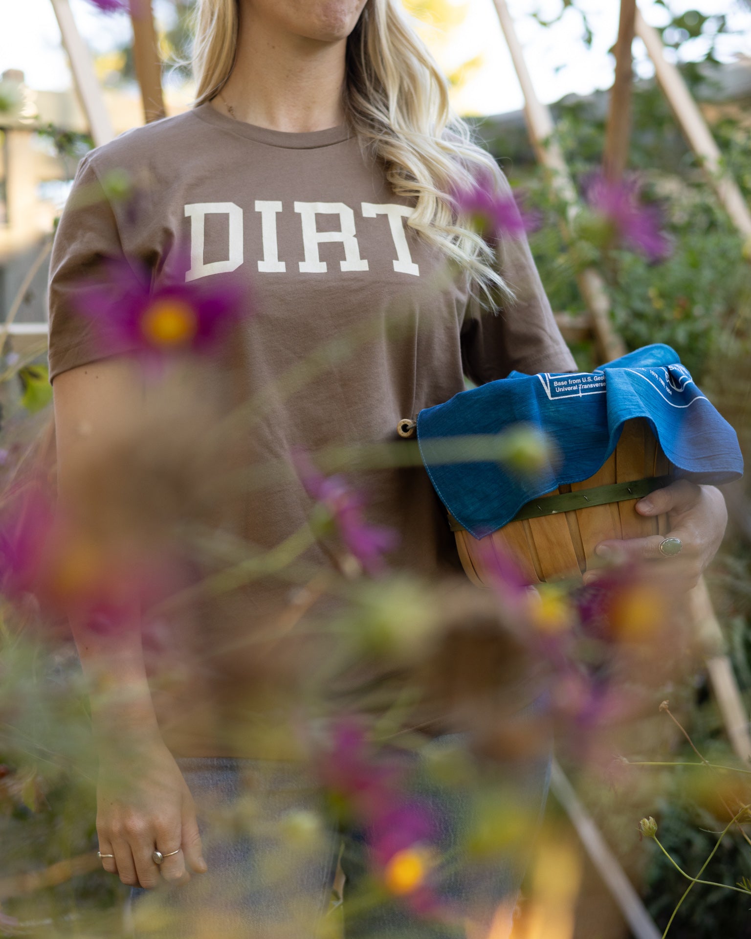 A person working in a garden while wearing The Dirt T in vintage brown, designed for gardening or adventures in the dirt.